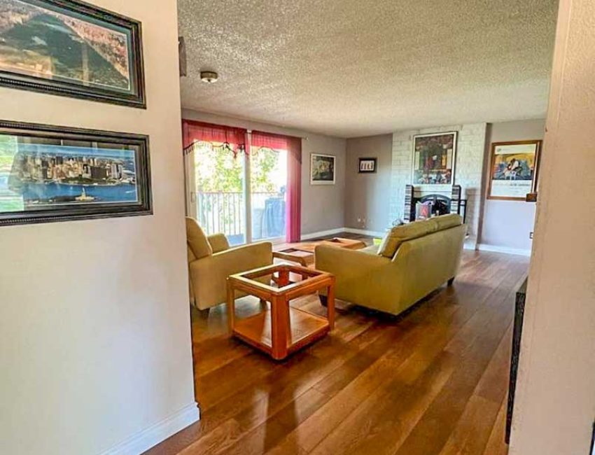 Polished dark hardwood flooring in a traditional living room with framed art