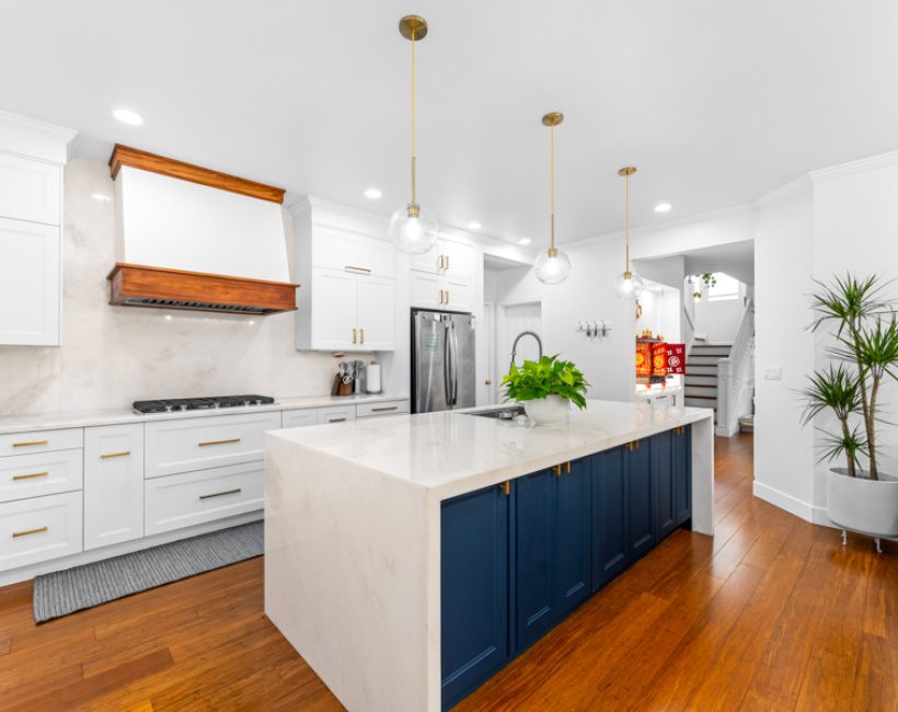 White kitchen with navy island and hardwood flooring installed by Simple Floor Solutions in Maple Valley, WA