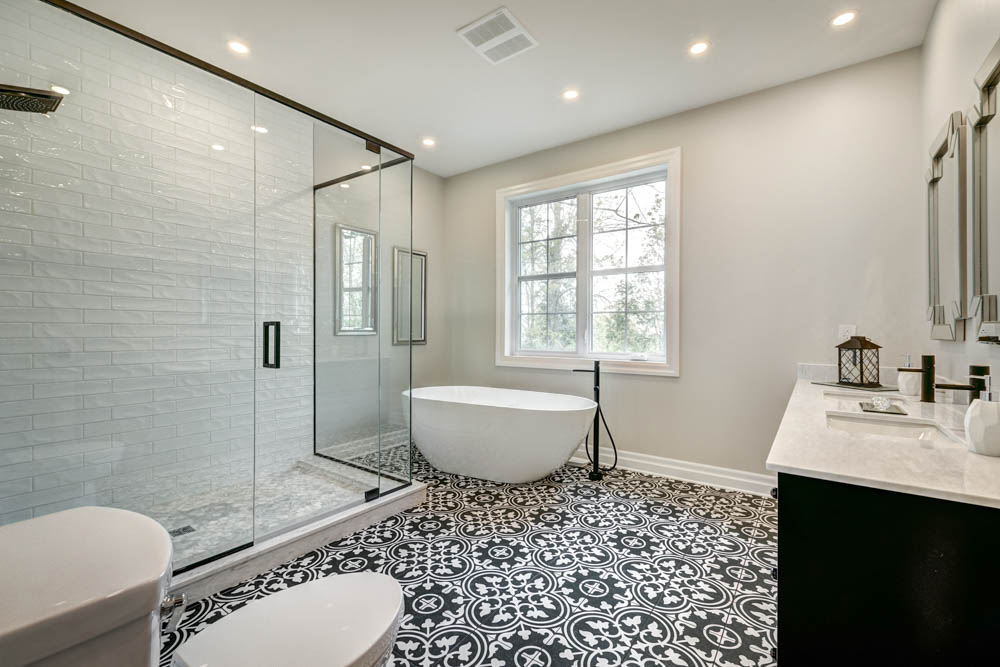 Modern bathroom with patterned tile flooring, freestanding tub, and glass shower installed by Simple Floor Solutions